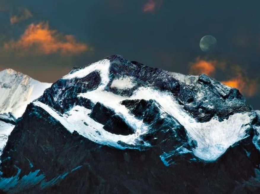Sacred Om Parvat peak with the holy snow Om etched under twilight sky and moon